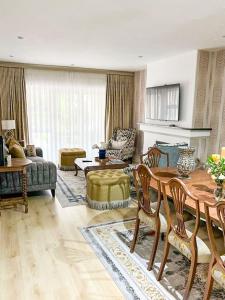 Una gran sala de estar con mesa y sillas. en Balgowan Estate Sandton, en Johannesburgo