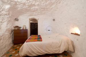 a bedroom with a bed and a dresser in a wall at La Constanza Casa Cueva by ASH in Granada +46 photos