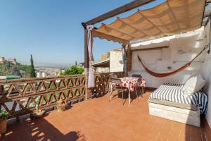 a balcony with a table and a bed and a table at La Constanza Casa Cueva by ASH in Granada