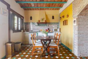 a kitchen with a table and chairs in a room at La Constanza Casa Cueva by ASH in Granada
