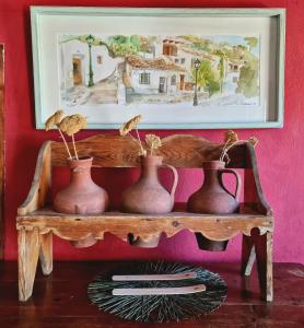 a shelf with three vases on it with a picture at La Constanza Casa Cueva by ASH in Granada