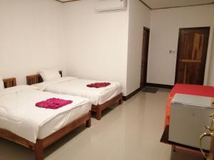 two beds in a room with white walls at ชมวิว บึงโขงหลง in Ban Don Klang