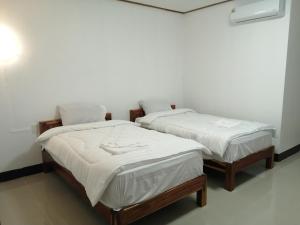 two beds with white sheets in a room at ชมวิว บึงโขงหลง in Ban Don Klang