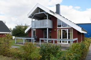 a red house with a bench in front of it at Seeschwalbe Classic 75A in Rechlin
