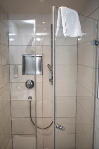a shower with a glass door with a towel on it at Hotel Obertor in Ravensburg