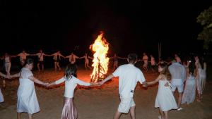 a group of people standing around a bonfire at Stop And Go Lang Chai Boutique Resort in Phan Thiet +79 photos