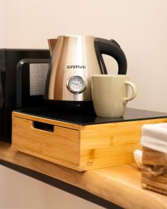 a coffee pot and a cup sitting on a microwave at Sassimori casa vacanza in Chiampo