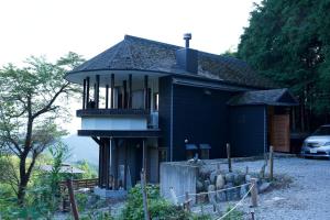 a black house with a balcony on the side of it at フォレスタ風影山荘 in Hanno