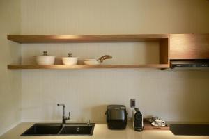 Ấp Ða LợiにあるLà Yên Retreatのシンクと電子レンジ付きのキッチンカウンター +148枚の写真