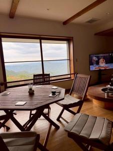 a living room with a wooden table and chairs at フォレスタ風影山荘 in Hanno
