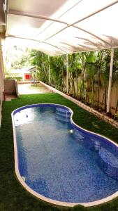 a large blue swimming pool under a tent at Tania President Inn in Shirdi