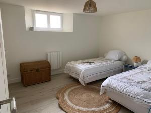 a bedroom with two beds and a rug at Séjour Entre Océan et Centre-Ville in Hossegor