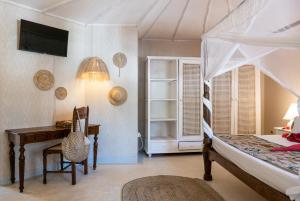 une chambre avec un lit, un bureau et une table dans l'établissement Crystal Bay Resort, à Watamu