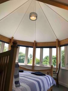 - une chambre avec un lit dans une tente avec des fenêtres dans l'établissement Poole Manor House, à Lytchett Matravers