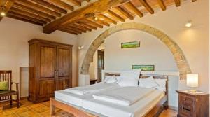 a bedroom with a large white bed with an archway at Tenuta Seripa in Sassetta +187 photos