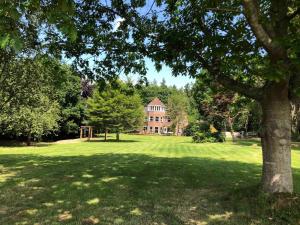 une grande maison au milieu d'un champ verdoyant dans l'établissement Poole Manor House, à Lytchett Matravers