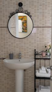 a bathroom with a sink and a mirror at 6 appartamenti per gruppi fino a 20 persone in Viarigi