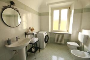 a bathroom with a sink and a toilet and a mirror at 6 appartamenti per gruppi fino a 20 persone in Viarigi +23 photos