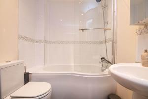 a bathroom with a tub and a toilet and a sink at Vine Mews - 2 Bed in Warwick