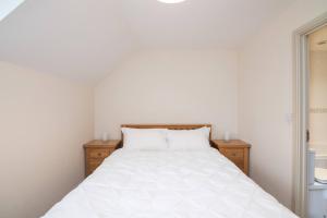 a bedroom with a white bed with two night stands at Vine Mews - 2 Bed in Warwick +13 photos