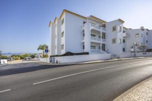 a large white building on the side of a street at CoolHouses Algarve Luz, Ramalhete in Luz