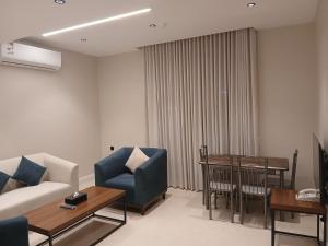 a living room with a couch and a table at رؤوم إن للشقق المخدومة -شقراء-Raoum Inn Serviced Apartments-Shaqraa in Shaqra