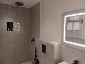 a bathroom with a shower and a mirror at رؤوم إن للشقق المخدومة Raoum Inn Serviced Apartments-Shaqraa in Shaqra +51 photos