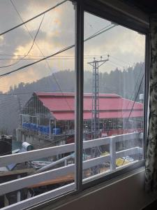 a window with a view of a dock and a building at Umda Hotel Galaxy in Dargai