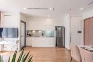 een keuken met witte kasten en een roestvrijstalen koelkast bij Nanahousing-Apartment Vinhomes Skylake #1BR#2BR#3BR in Hanoi +27 foto's