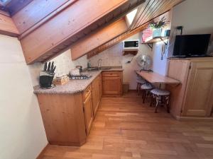 a kitchen with wooden cabinets and a wooden table at Mansardina Il Nido in Padola