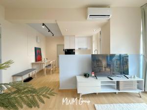 a living room with a white cabinet and a kitchen at Black White Sea Salt Theme Midas Seri Alam in Masai