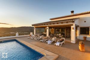eine Villa mit einem Pool und Liegestühlen in der Unterkunft Villa Sapphire by Abahana Villas in Teulada