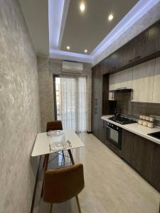 une cuisine avec une table et des chaises dans une pièce dans l'établissement Посуточная аренда квартиры в Ташкенте для гостей, à Tachkent 1 autre photo