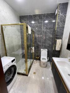 une salle de bain avec douche et machine à laver dans l'établissement Посуточная аренда квартиры в Ташкенте для гостей, à Tachkent