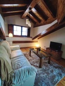 a living room with a couch and a coffee table at Apartamentos El Caballar in Sandoñana