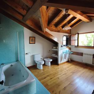 a large bathroom with a tub and a toilet at Apartamentos El Caballar in Sandoñana +14 photos