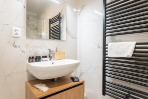 a white bathroom with a sink and a mirror at Krkonošský šarm in Hořejší Vrchlabí +35 photos