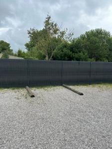 two logs laying on the ground in front of a fence at Unusual converted bus for couples or families in Berck-sur-Mer