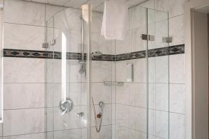 a bathroom with a shower with a glass door at Hotel Obertor in Ravensburg