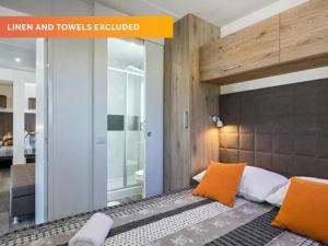 波雷奇Valamar Camping Lanterna - Roan的卧室里有一张带橙色枕头的床 更多25张照片