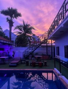 a house with a swimming pool with a sunset at Angkor Sunshine Oasis in Siem Reap