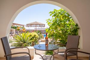 a patio with a table with wine glasses on it at Aeolos Hotel in Koufonisia