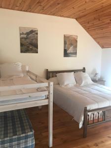 ein Schlafzimmer mit zwei Betten und einer Holzdecke in der Unterkunft Gite Galy - Maison de montagne in Cazeaux-de-Larboust