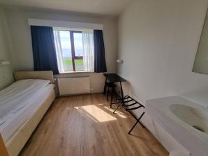una camera con letto, lavandino e finestra di Litla-Hof Guesthouse a Hof