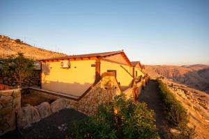 a house on the side of a mountain at Ramses Tafilah Lodge نزل رمسيس الطفيلة in At-Tafilah