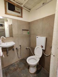 a bathroom with a toilet and a sink at Anantara Farmhouse Kitchen & Stay in Silāri