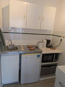 a small kitchen with a sink and a stove at Appart T1bis 31m2 Blagnac proche Tram in Blagnac