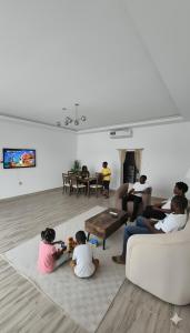 a group of people sitting in a living room playing a video game at Farmhouse-Villa--فيلا-المزرعة in Hatta