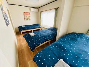 Dos camas en una habitación pequeña con sábanas azules con estrellas. en secondhouse - Vacation STAY 80543v, en Otaru