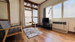 sala de estar con sofá, TV y ventana en secondhouse - Vacation STAY 80543v, en Otaru